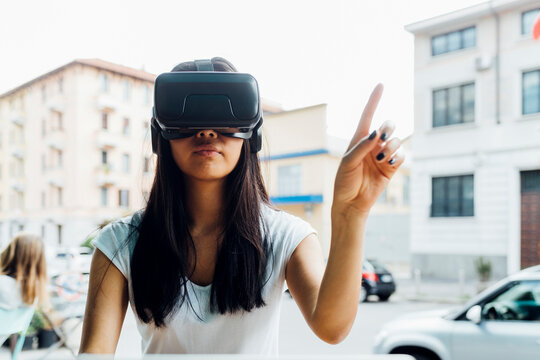 Young woman gesturing wearing virtual reality simulator