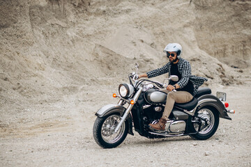 Obraz na płótnie Canvas Handsome man with his moto in sand quarry