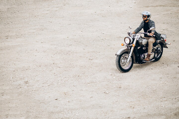 Obraz na płótnie Canvas Handsome man with his moto in sand quarry