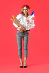 Fototapeta Beautiful young woman with flag of France and baguette on red background obraz