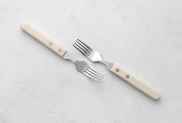 Stylish stainless steel forks on light background