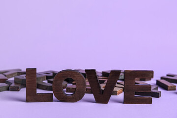 Word LOVE with letters on lilac background. Alphabet concept