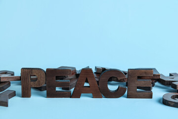 Word PEACE with letters on blue background. Alphabet concept