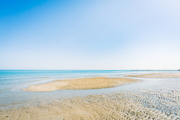 View of the Adriatic Sea from the sandy beach in Pesaro, Italy, during a sunny spring day