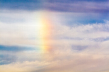 Rainbow in the clouds. Fragment of the natural phenomenon rainbow in the sky.