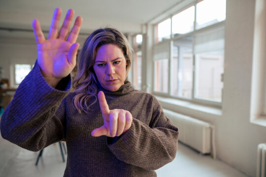 Businesswoman Using Augmented Reality Gesturing In Work Place