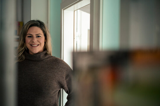 Smiling businesswoman standing at doorway in office