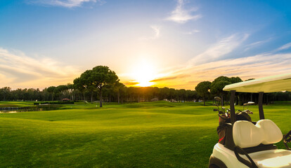 Panorama of golf cart on beautiful golf course at sunset