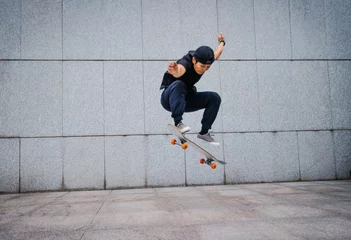 Foto auf Acrylglas Asian woman skateboarder skateboarding in modern city © lzf