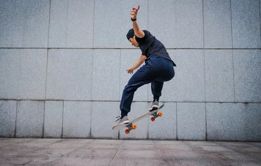 Fotobehang Asian woman skateboarder skateboarding in modern city © lzf