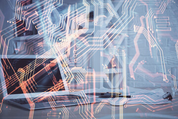 Computer on desktop in office with technology theme hologram. Multi exposure. Tech concept.