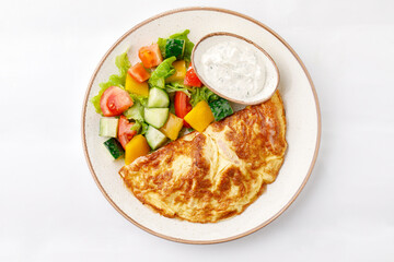 Omelet with ham and cheese and salad on a white background