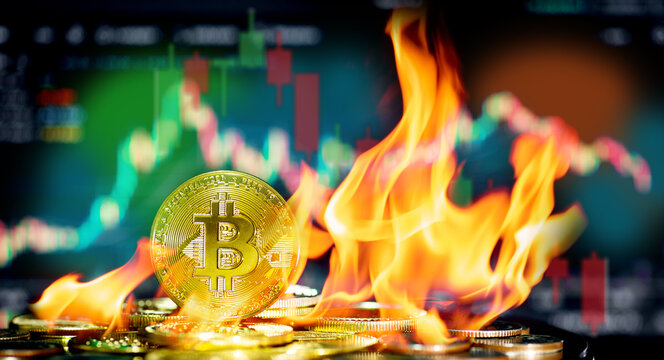 Burning golden bitcoin coin sits on a stack of cryptocurrencies