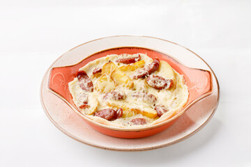 Potatoes with salami and cheese on a white background