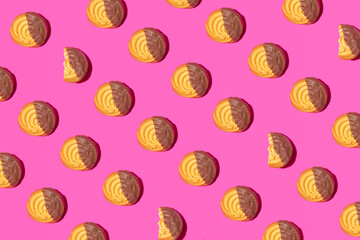 Chocolate glazed cookies, creative pattern on hot pink background. Retro style background. 