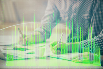 Multi exposure of forex chart with man working on computer on background. Concept of market analysis.