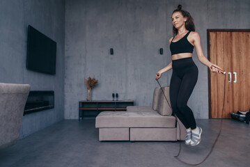 Sportsgirl with skipping rope at home.