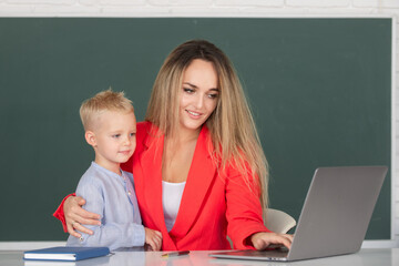 Mother and son together using computer laptop. School child learning education online lesson. Teacher explains lesson to school child. Elementary school kids learning. Mother and son learning.