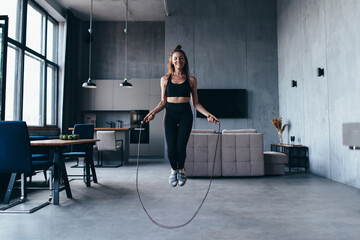 Fototapeta na wymiar Fit woman with jump rope at home doing skipping workout.
