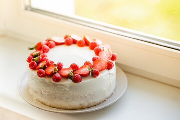 Delicious biscuit cake with cream cheese and berries. Light cake with strawberries and raspberries. Handmade cake. close up, copy space background