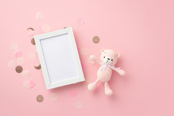 Baby girl concept. Top view photo of photo frame knitted teddy-bear toy and shiny confetti on...
