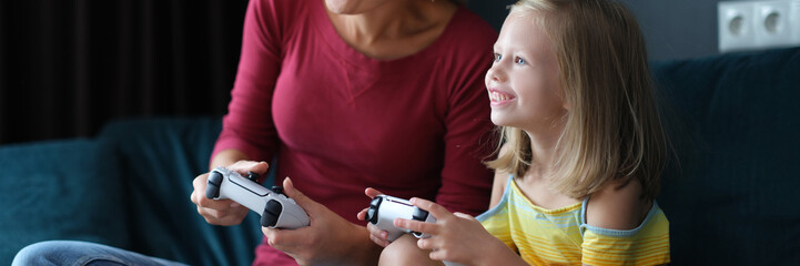 Mom and daughter are playing video games at home