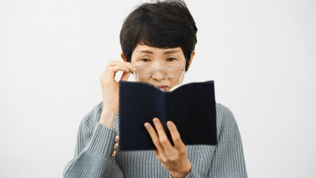 老眼鏡で読書をするミドル女性