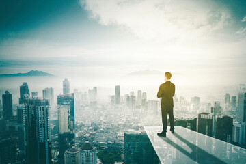 Confident male manager looking at misty city