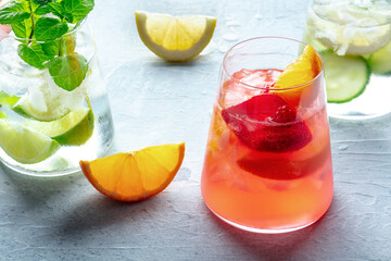 Summer cocktails. Cold drinks with fresh fruits. Healthy mocktails. Citrus, strawberry and cucumber lemonade, vibrant party style