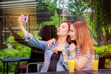 Lesbian couple taking selfie in cafe while dating