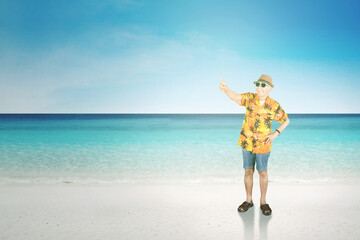Senior man pointing at something on tropical beach