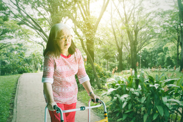 Senior woman walking with a walker at the park