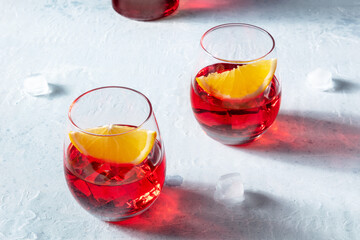Negroni aperitif cocktail with aperol, campari and fresh oranges, a cold drink, on a slate...