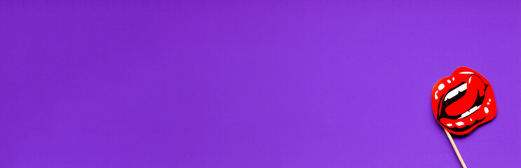Beauty banner. The shape of red plump lips on a purple background. Lip augmentation concept....
