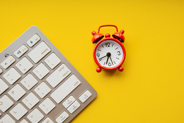 Red alarm clock and keyboard. Business deadline, schedule and urgent tasks concept