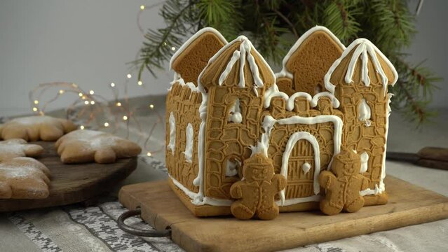 Gingerbread house Christmas homemade baking. Gingerbread Man. astle with white icing. Cookies in the shape of a Christmas tree and snowflakes on the table. Food for dessert. Winter gingerbread.