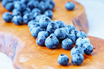 Juicy blueberry on a wooden board. Soft focus.
