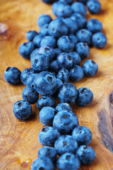 Ripe blueberries on a wooden background. Vertical composition.