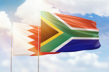 Sunny blue sky and flags of south africa and bahrain