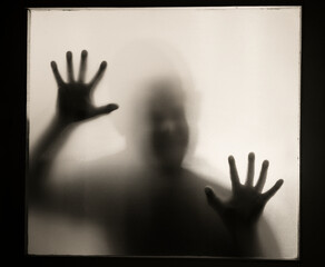 Fototapeta premium Shadowy figure behind glass - horror background