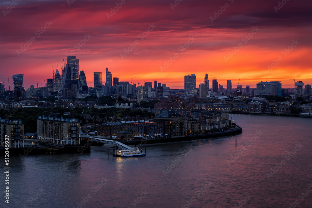 Wall mural the illuminated london skyline with river thames and skyscrapers during a fiery summer sunset, engla