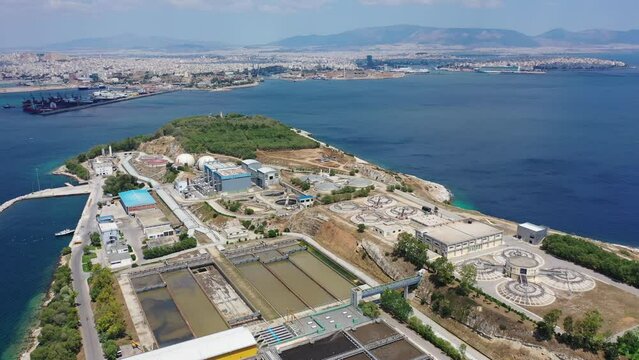 Aerial drone flyover video of small island of Psitaleia a latest technology industrial water sewage plant near Perama, Attica, Greece
