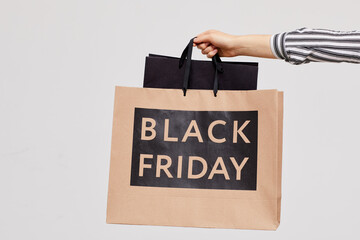 Fototapeta na wymiar Close-up of unrecognizable woman holding paper bags while enjoying Black Friday shopping in mall