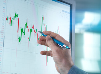 Trader analyzing stock market data on computer at office