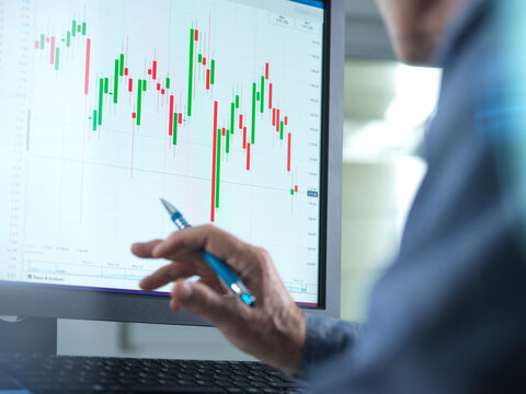 Stockbroker Analyzing Share Price On Computer At Office