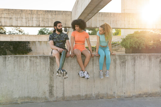 group of friends sitting after playing sports, man with amputated leg and prosthesis, explains to his friends how he lost his leg, sitting outdoors