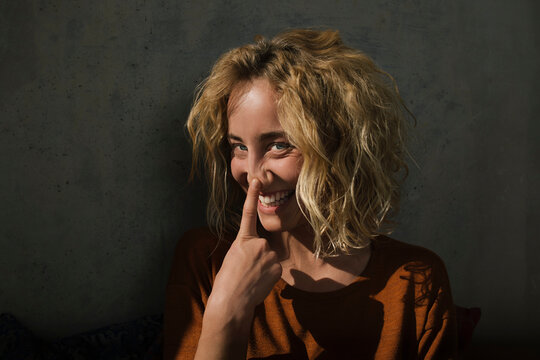 Portrait of laughing blond woman pulling funny faces
