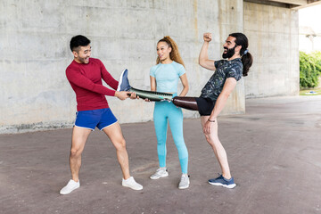 man with amputated leg, shows his prosthesis to his friends, multiracial, having fun with prosthesis in his hand. sport concept