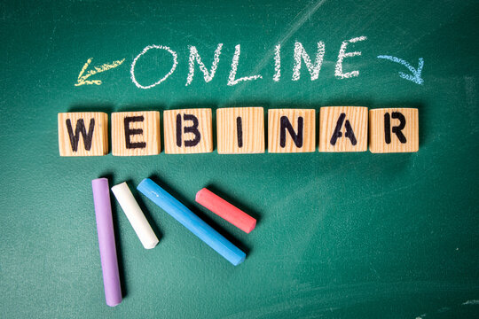 Online Webinar. Wooden alphabet letters and pieces of chalk on a green chalk board