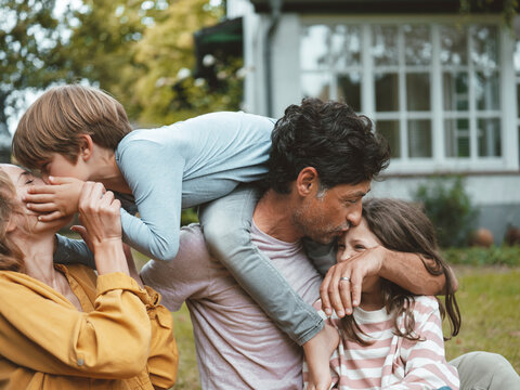 Family embracing each other sitting in back yard